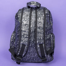 Load image into Gallery viewer, The Rustic Silver Spider Backpack sat on a purple background. The bag is facing away to highlight the two padded shoulder straps, the top handle and two elasticated side pockets. The vegan friendly faux leather bag has 3d embossed spiders in varying sizes with brushed black and silver tones all over.