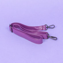 Load image into Gallery viewer, The GothX Purple Coffin Bag detachable adjustable strap with metal d rings and lobster clips laying folded on a lilac background.