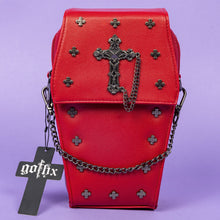 Load image into Gallery viewer, The GothX Red Mini Coffin Bag facing forward on a purple background. The coffin bag is made with vegan friendly sleek red leather and features a detachable decorative metal chain with a large metal cross and chain emblem with surrounding cross studs.