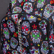 Load image into Gallery viewer, Close-up of the sugar skull print and silver chain detail on the front pocket of the CHOK GothX Sugar Skull Backpack, blending vibrant colours with edgy gothic fashion. Made from durable nylon material.
