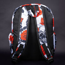 Load image into Gallery viewer, The back of the backpack displays a striking red rose and black skull pattern on white, with padded shoulder straps for comfort and style.