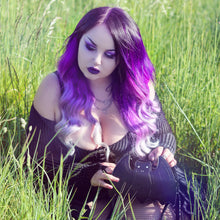 Load image into Gallery viewer, Azariah with long purple gradient hair wearing an all black goth outfit sat in a grass field holding the gothx black bat vegan shoulder bag.