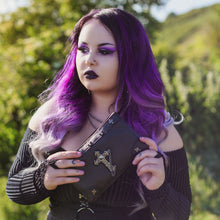 Load image into Gallery viewer, A model with long purple gradient hair in a goth outfit holding the gothx don't cross me vegan clutch bag. The clutch is facing forward to highlight the cross studs and stud, chain cross centrepiece.
