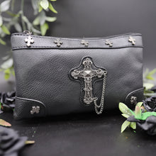 Load image into Gallery viewer, The gothx don't cross me vegan clutch bag on a black studio background with black roses and green foliage surrounding it. The clutch is facing forward to highlight the cross studs and stud, chain cross centrepiece.