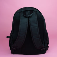 Load image into Gallery viewer, The Kawaii Black & Clear Window Vegan Ita Backpack on a pastel pink background. The bag is facing away from the camera to highlight the adjustable padded shoulder straps, side pockets and top handle.