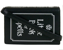 Load image into Gallery viewer, The gothx little book of spells vegan shoulder bag on a white studio background. The bag is resting on the 3d book edge shape to highlight the white printed pentagram and text front, white printed spine and detachable strap.