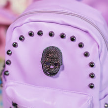 Load image into Gallery viewer, Close up of the diamante effect skull and dark grey stud detailing on the GothX Pastel Lilac Skull Head Small Studs Vegan Mini Backpack.