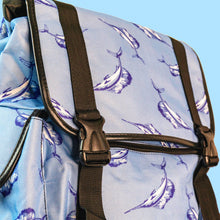 Load image into Gallery viewer, A pastel blue backpack with black buckle and strap detailing with swordfish printed all over. Close up of the black buckle close with black piping detailing.