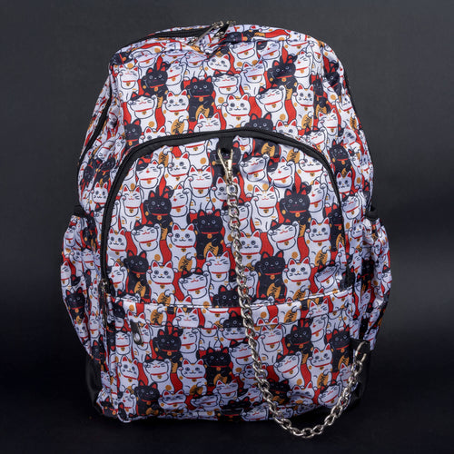 A gothic-inspired backpack by CHOK GothX featuring a vibrant lucky cat print in white, black, orange, and red. Includes a silver chain detail, multiple zip compartments, and a spacious design. Perfect for alternative fashion lovers.