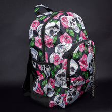 Load image into Gallery viewer, Side view of backpack showing multiple compartments – A side angle of the backpack, highlighting the multiple compartments and spacious design. The pink roses and skulls print covers all visible areas, giving the bag a cohesive gothic appearance.
