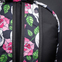 Load image into Gallery viewer, Close-up of front zip pocket with skull and rose pattern – A detailed view of the backpack’s front zip pocket, showing the intricate skull and pink rose pattern. The silver chain accessory hangs from the zipper, enhancing the alternative style.
