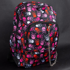 Side view of the CHOK GothX backpack, highlighting bold pink skulls and crossbones in pink, red, and white. Designed for durability and comfort, it features side pockets, padded straps, and edgy chain details. Perfect for alternative fashion enthusiasts.