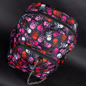 A gothic backpack by CHOK GothX featuring a vibrant pink skull and crossbones print in pink, red, and white on a black background. It has multiple compartments, padded adjustable straps, and edgy silver chain detailing. Designed for laptops up to 15 inches, this bag is durable, spacious, and perfect for alternative fashion lovers.