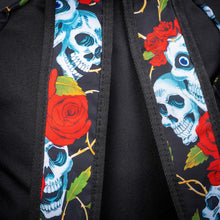 Load image into Gallery viewer, Close-up of shoulder straps with skull and rose print – Detailed view of the backpack’s shoulder straps, showcasing the blue skull and red rose pattern, with golden vines against a black background. The contrast of colours adds a striking touch.
