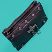 Load image into Gallery viewer, The gothx dont cross me vegan clutch bag sat on a teal background. The clutch is facing forward to highlight the top zip compartment, cross studs and stud and the chain cross centrepiece.
