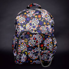 Load image into Gallery viewer, Full front view of sugar skull backpack with colourful floral designs – Full front view of the backpack, featuring a bright sugar skull design, festive floral patterns, and a chain accent on the zipper, making it a stand-out accessory.
