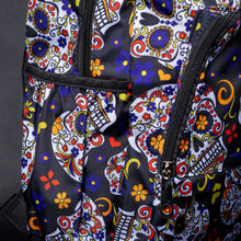 Load image into Gallery viewer, Side view of backpack showing multiple compartments with sugar skull design – A side angle showing the spacious compartments, each adorned with colourful sugar skulls and floral details, creating a vibrant and stylish look.
