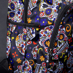 Side view of backpack showing multiple compartments with sugar skull design – A side angle showing the spacious compartments, each adorned with colourful sugar skulls and floral details, creating a vibrant and stylish look.