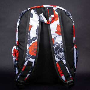 The back of the backpack displays a striking red rose and black skull pattern on white, with padded shoulder straps for comfort and style.