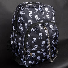 Load image into Gallery viewer, Angled view of the CHOK GothX backpack featuring a white skull print, silver chain, and multiple zips. Lightweight yet spacious with padded straps, perfect for daily use or travel with a gothic twist.
