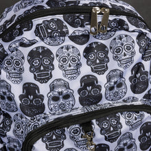 Load image into Gallery viewer, A white backpack featuring black sugar skulls and silver hardware details by CHOK GothX. This alternative design is perfect for gothic and spooky fashion enthusiasts seeking a practical yet stylish accessory.
