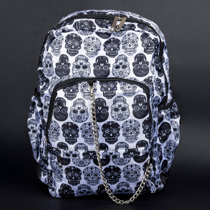 A white gothic backpack with a black sugar skull print and silver chain detail by CHOK GothX. The bag features spacious compartments, sturdy zippers, and a bold alternative design, ideal for fans of edgy and spooky fashion styles.