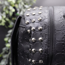 Load image into Gallery viewer, Close up of the gothx embossed skull vegan backpack main zip compartment to highlight the silver studded edge and all over embossed skull design.
