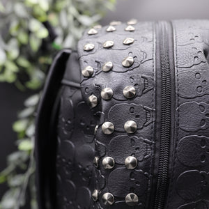 Close up of the gothx embossed skull vegan backpack main zip compartment to highlight the silver studded edge and all over embossed skull design.