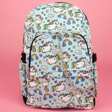 Load image into Gallery viewer, The kawaii unicorn vegan backpack sat on a pink background. The bag is facing forward to highlight the pastel blue rainbow unicorn print, two front zip pockets, two side pockets and detachable silver chain.

