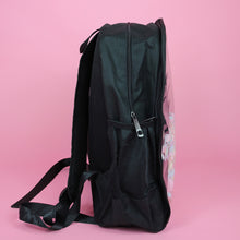 Load image into Gallery viewer, The Kawaii Black &amp; Clear Window Vegan Ita Backpack on a pastel pink background. The bag is facing right filled with pastel confetti and pom poms to highlight the clear display window, double zip opening, side pockets and padded adjustable shoulder straps.
