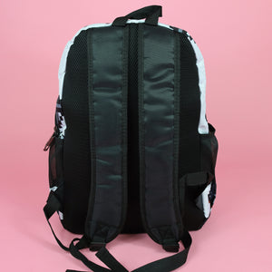 The white game over vegan backpack on a pink studio background. The vegan friendly bag is facing away to highlight the plain black back with two padded adjustable shoulder straps, two elasticated side pockets and top handle.