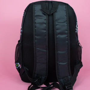 The black game over vegan backpack on a pink studio background. The bag is facing away to highlight the plain black back, side pockets, padded shoulder straps and top handle.