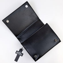 Load image into Gallery viewer, The GothX Ouija Spirit Book Mini Bag laying open on a white background to show the two magnetic clip closures, zipped middle and plain black vegan leather inside.
