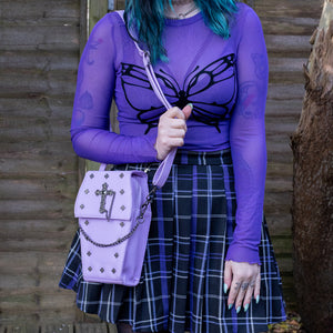 The GothX Pastel Lilac Mini Coffin Vegan Cross Body Bag being held up by a gothic alternative model. The vegan friendly pastel leather bag is facing forward to highlight the cross studs, cross & chain centrepiece, detachable chain and detachable adjustable shoulder strap.