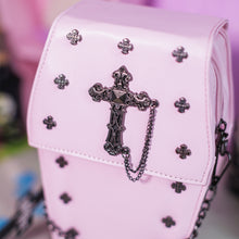 Load image into Gallery viewer, Close up of the mini cross studs, cross chain centrepiece and the magnetic clip close of the GothX Pastel Pink Mini Coffin Vegan Cross Body Bag.
