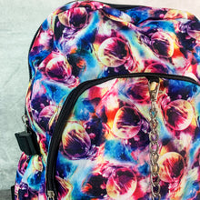 Load image into Gallery viewer, Close up of the planets solar system vegan backpack on a grey velvet background to highlight the front zip pocket, silver chain and multicoloured planet front print.
