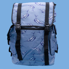 Load image into Gallery viewer, The Blue Swordfish Vegan backpack on a blue studio background. A pastel blue backpack with black buckle and strap detailing with swordfish printed all over. The bag is facing forward open to highlight the side buckle pockets, drawstring and buckle close and black piping detailing.
