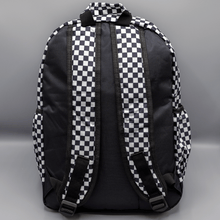 Load image into Gallery viewer, The White Checkerboard Backpack sat on a grey background. The vegan friendly bag features an all over mini black and white check print with black trim along the silver zips. The bag is facing away from camera to highlight the plain black back, the top handle and adjustable padded shoulder straps.

